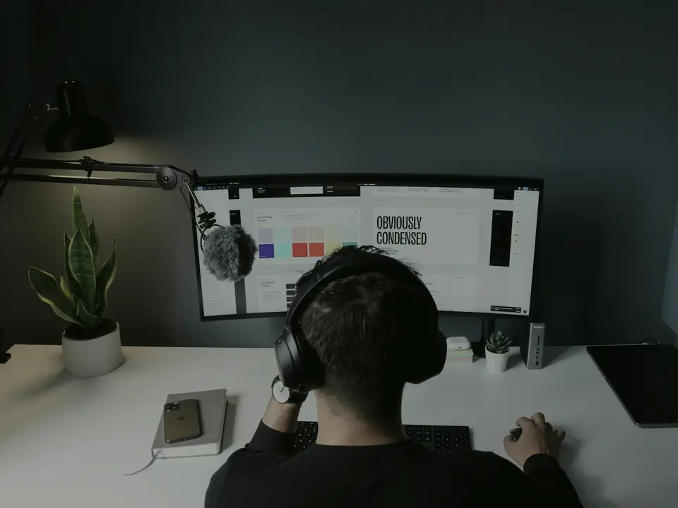 Diseñador trabajando en la retícula de una interfaz en un monitor de escritorio